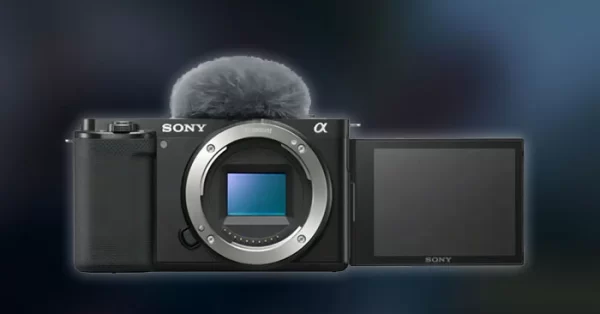 Câmera Sony ZV-E10 preta com a tela articulada virada para frente e microfone com deadcat, ideal para vlogs.